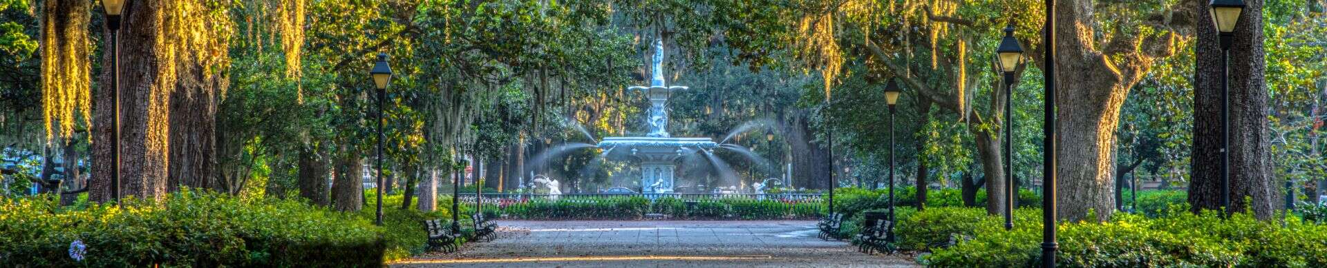Forsyth Park fountain surrounded by trees and walking paths in Savannah.
