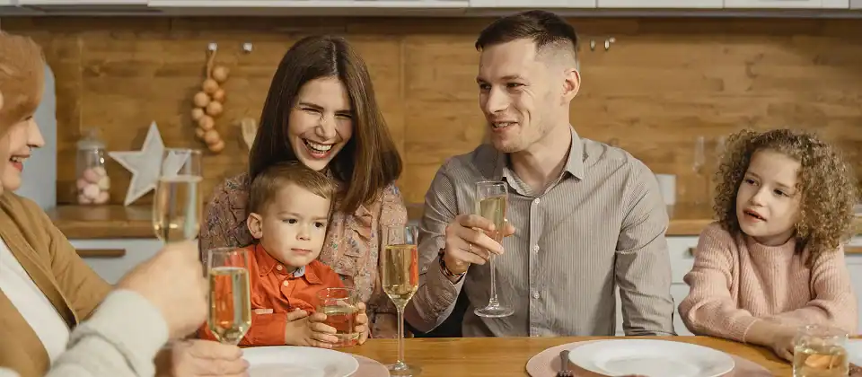 Multigenerational family toasting with champagne at a holiday dinner table